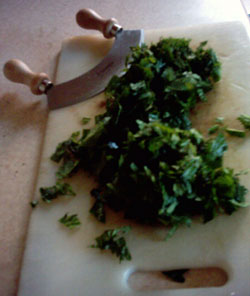 Chopped nettles on a board with a mezzaluna herb knife Chopped nettles on a board with a mezzaluna herb knife