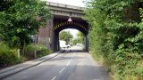 The route follows the pavement under this railway bridge